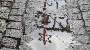 Spiegelung der Weihachtsmarkt-Dekoration in Pfütze