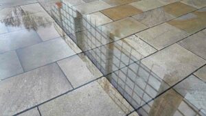 Geschäftshaus spiegelt sich in einer Pfütze auf der Neuen Straße