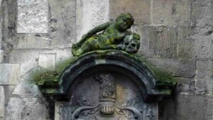 Ein Engel macht ein Nickerchen auf einem Totenkopf (Fassade St. Martini)