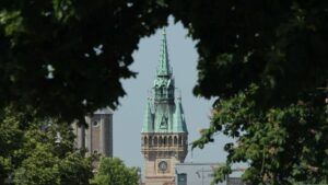 Turm des Rathaus-Altbaus umrahmt von Bäumen (aufgenommen von der Helmstedter Straße)