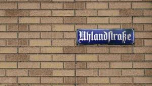 Altes Emaille-Straßenschild in der Uhlandstraße auf Pseudo-Klinkerfassade