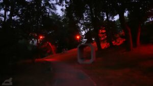 Lichtparcours 2024 - Oberserver (die unspektakulärste Installation - zwei Holzcontainer mit Sitzbänken, die rot angestrahlt werden)