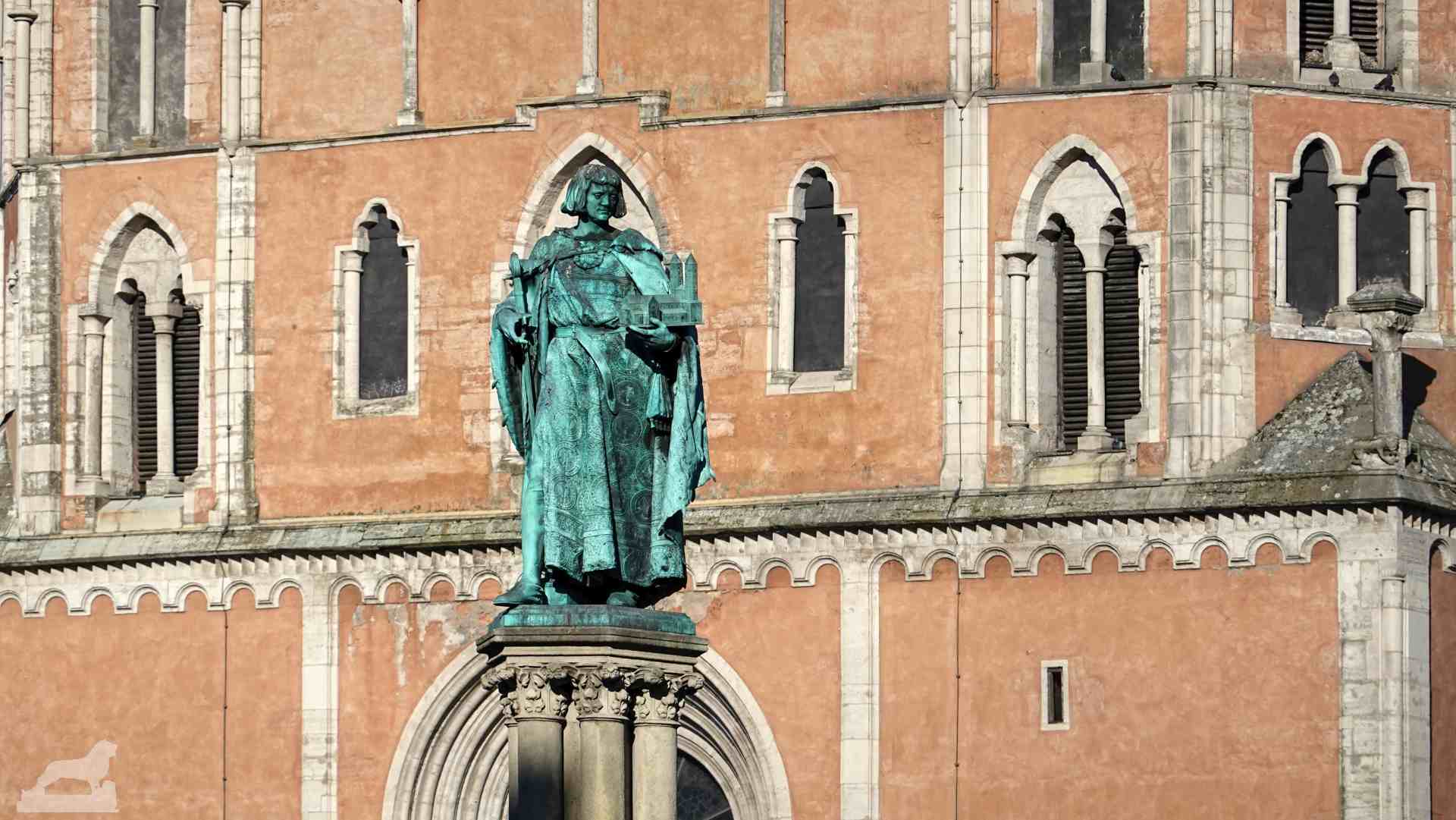 Figur Heinrich des Löwens auf dem Heinrichsbrunnen, im Hintergrund St. Katharinen