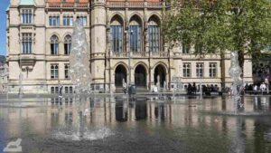 Der Rathaus-Altbau spiegelt sich im Wasserspiel auf dem Platz der Deutschen Einheit