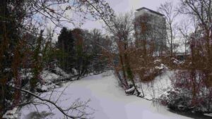 verschneite Oker mit TU-Hochhaus im Hintergrund