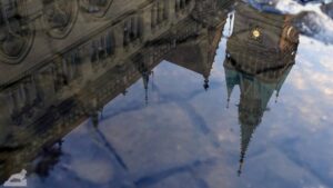 Spiegelung der Rathaus-Altbaus in einer Pfütze