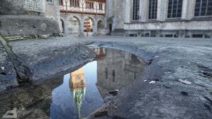 Spiegelung der Rathausturm in der Sockelrinne des Burglöwen
