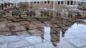 Burg Dankwarderode spiegelt sich in einer Pfütze auf dem Burgplatz